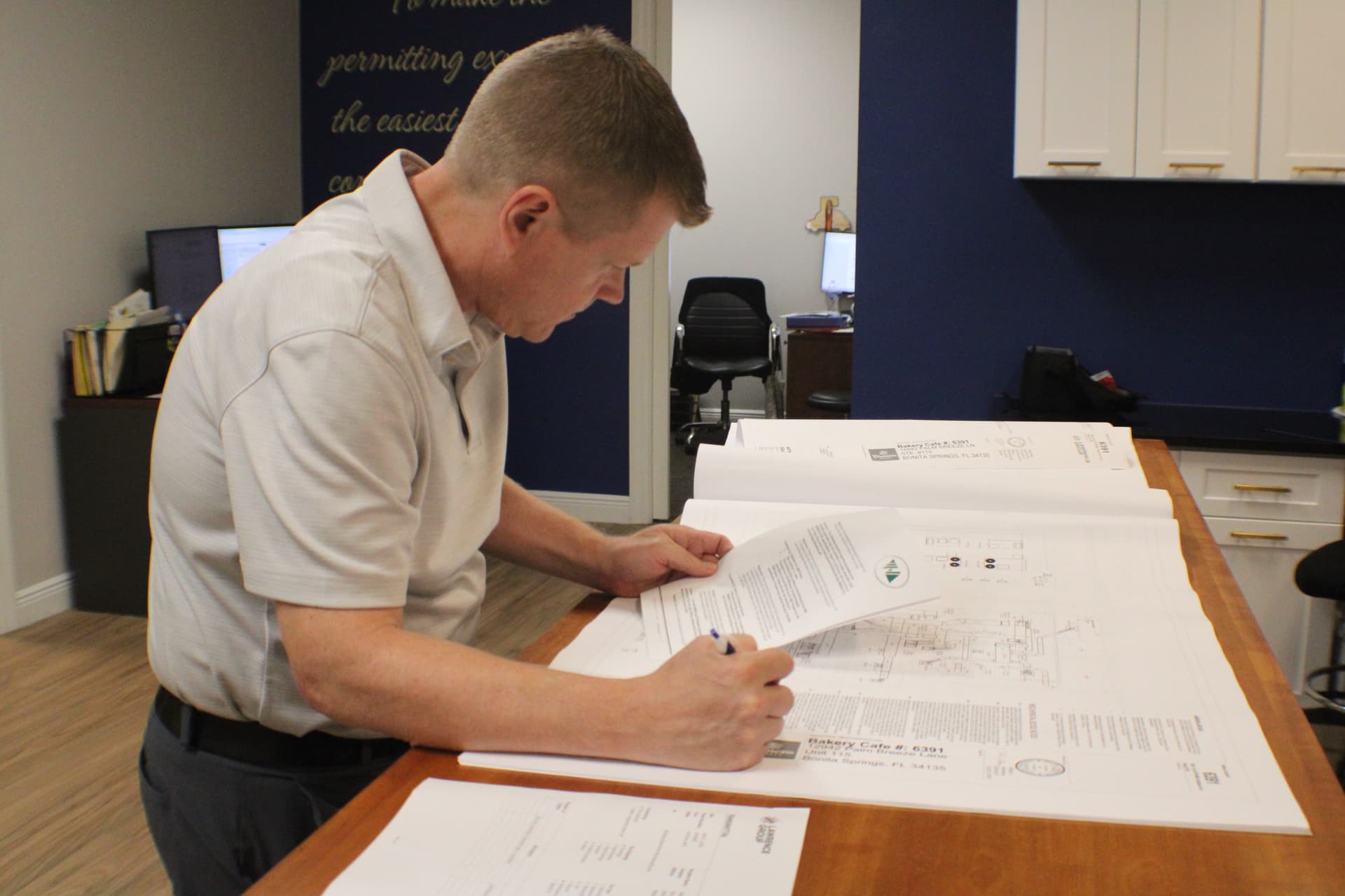 Elite Permits coordinator reviewing blueprints